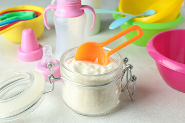Concept of baby food with рowdered milk on white textured background