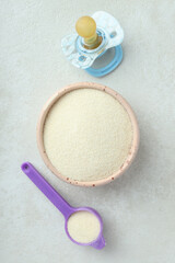 Concept of baby food with рowdered milk on white textured background