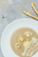 Champignon puree soup with parmesan and fried mushroom slices. vertical image. top view. place for text