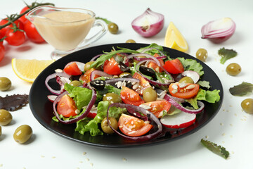 Concept of tasty food with vegetable salad with tahini sauce on white background