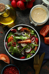 Concept of tasty food with vegetable salad with tahini sauce on dark textured background