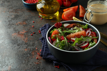 Concept of tasty food with vegetable salad with tahini sauce on dark textured background