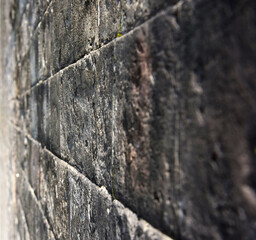A wall of rough, dark stone looking into perspective
