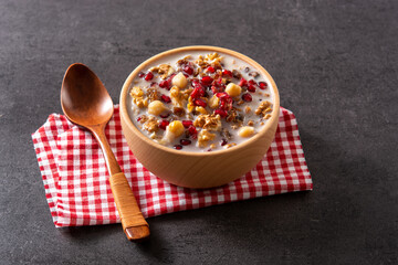 Traditional Turkish Noah's pudding in bowl on black background