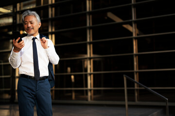 Senior businessman outdoors. Middle-aged businessman using the phone..