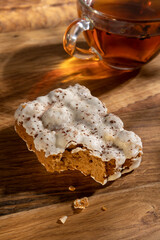 Vertical image of bitten termisu biscuit and glass cup of black tes on the wooden table