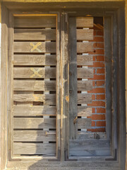 window of an old abandoned house covered with planks and bricks