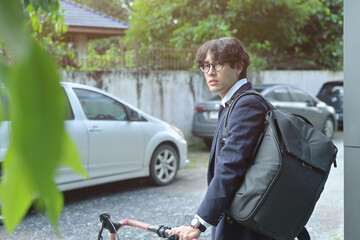 Photo of a young stylish businessman going to work by bike. Transportation in a crowded city...