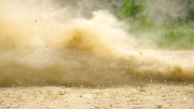 Close up wheel of powerful off-road motorcycle starting movement. Motocross bike starts move. Dry ground or dust flying around. Concept of motorsport or active lifestyle. Slow motion Side view