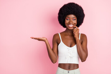 Photo portrait curly girl in white top biting nail keeping blank space on hand isolated pink color background copyspace