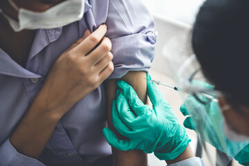 Young woman visits skillful doctor at hospital for vaccination . Covid 19 and coronavirus...
