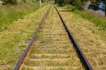 Obraz premium Circum-Baikal Railway, Russia. old railway with wooden sleepers. Mowed grass along the rails.