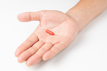 男性の手のひらに載せたカプセル状の飲み薬