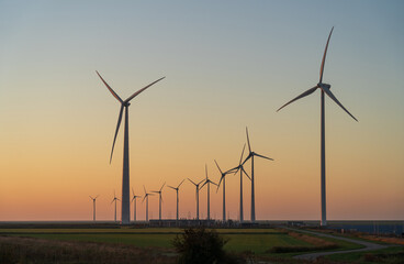 Wind turbines spinning in the countryside during dusk.