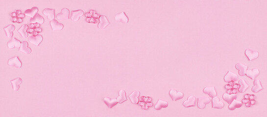 Pink satin hearts in a corner arrangements on paper texture for Valentine Day