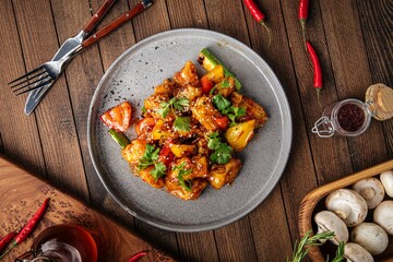 Asian cooked zander fish in sweet and sour sauce on wooden background