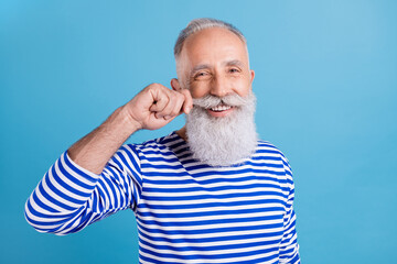 Portrait of attractive cheerful grey-haired man touching mustache grooming styling isolated over bright blue color background