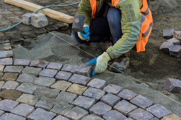 Installation of paving stone granite cubes on a sandy base