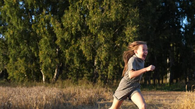 Little happy girl and her sister running after each other in the park