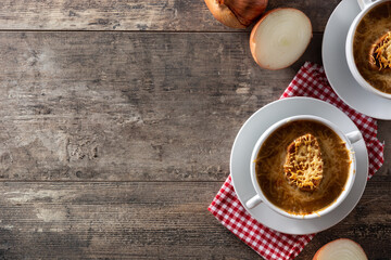 Traditional french onion soup on wooden table. Top view. Copy space