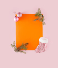 Minimal New Year concept with Christmas decoration on pastel pink and orange background.