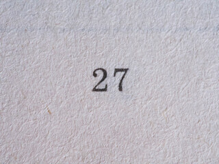 The number 27 printed on a piece of paper. Paper texture.