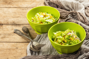 Tasty vegan salad from Chinese cabbage, sweet corn, purple onion, and dressing