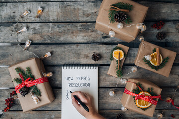 New Year Concept. 2022 NEW YEAR'S RESOLUTIONS hand written text in notebook on wooden background....