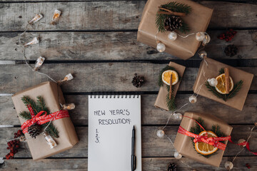 New Year Concept. 2022 NEW YEAR'S RESOLUTIONS hand written text in notebook on wooden background....