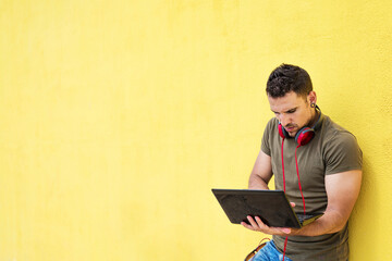 man holding laptop computer isolated on yellow background