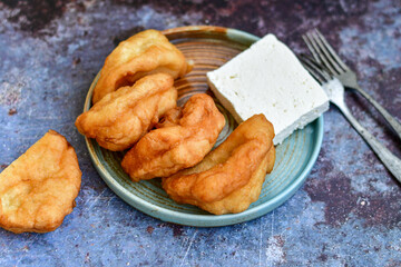 Traditional Bulgarian home made deep fried  patties  covered with sugar  оn rustic backgroud.Mekitsa or Mekica,  on wooden  rustic  background. Made of kneaded dough that is deep fried 