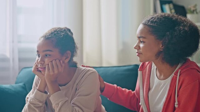 Kind teen girl supporting hugging unhappy sister, sibling relationship, family