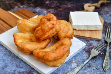 Traditional Bulgarian home made deep fried  patties  covered with sugar  оn rustic backgroud.Mekitsa or Mekica,  on wooden  rustic  background. Made of kneaded dough that is deep fried 