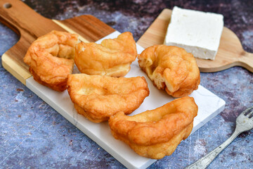 Traditional Bulgarian home made deep fried  patties  covered with sugar  оn rustic backgroud.Mekitsa or Mekica,  on wooden  rustic  background. Made of kneaded dough that is deep fried 