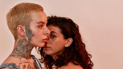 Closeup portrait of two young generation Z lesbian couple posing together isolated over light pink background