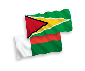 National vector fabric wave flags of Co-operative Republic of Guyana and Madagascar isolated on white background. 1 to 2 proportion.