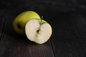 Close up of Apple fruit cut at half on wooden background.