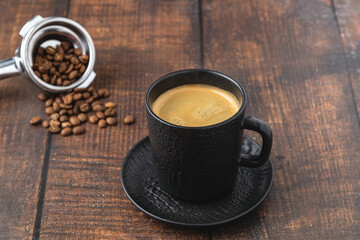 Relaxing americano coffee in black porcelain cup on wooden table