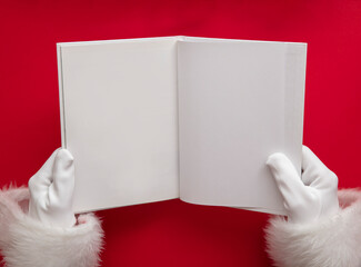 Santa claus holding a book with blank pages. Christmas book mockup