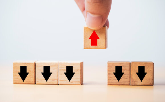 Hand holding increasing red arrow which move out and opposite way from black decreasing arrow for business and technology disruption concept.