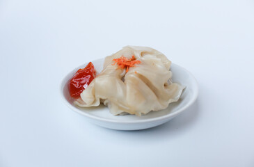 Affordable version of dumplings, with a small packet of sauce. Isolated on white background