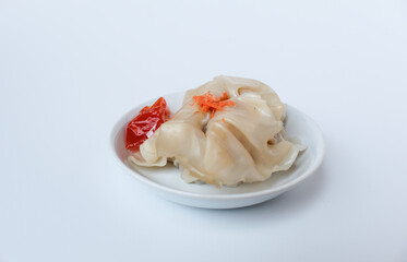 Affordable version of dumplings, with a small packet of sauce. Isolated on white background