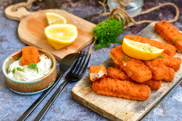  Fish and chips.Close up of crispy breaded  deep fried alaska pollock  fillets  with breadcrumbs served with remoulade sauce french fries  and  lemons