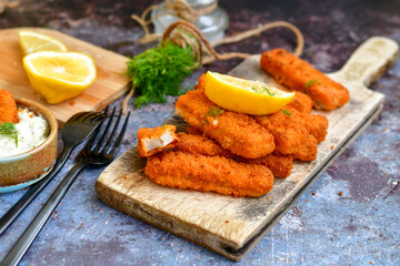  Fish and chips.Close up of crispy breaded  deep fried alaska pollock  fillets  with breadcrumbs served with remoulade sauce french fries  and  lemons