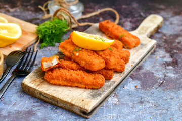  Fish and chips.Close up of crispy breaded  deep fried alaska pollock  fillets  with breadcrumbs served with remoulade sauce french fries  and  lemons