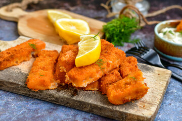  Fish and chips.Close up of crispy breaded  deep fried alaska pollock  fillets  with breadcrumbs served with remoulade sauce french fries  and  lemons