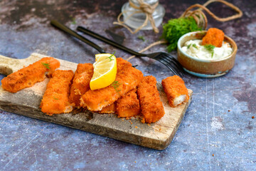  Fish and chips.Close up of crispy breaded  deep fried alaska pollock  fillets  with breadcrumbs served with remoulade sauce french fries  and  lemons