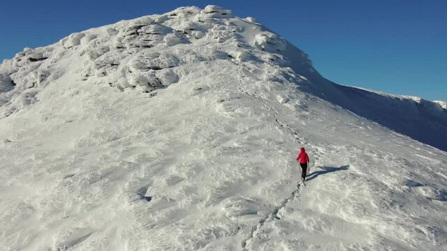 Aerial view of snow mountain range landscape. Climber Walking Up Mountain Expedition. winter drone footage. Carpathian Mountains, Ukraine