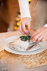 Women's hands with cutlery  setting on   table during   New Year