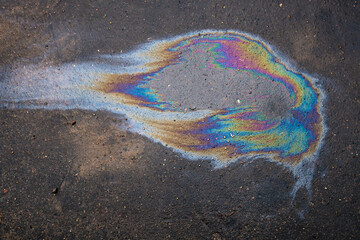 Spills of fuel or oil on the asphalt road as texture or background.